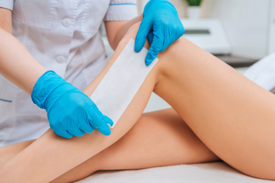 A woman having a waxing service at a beauty spa.